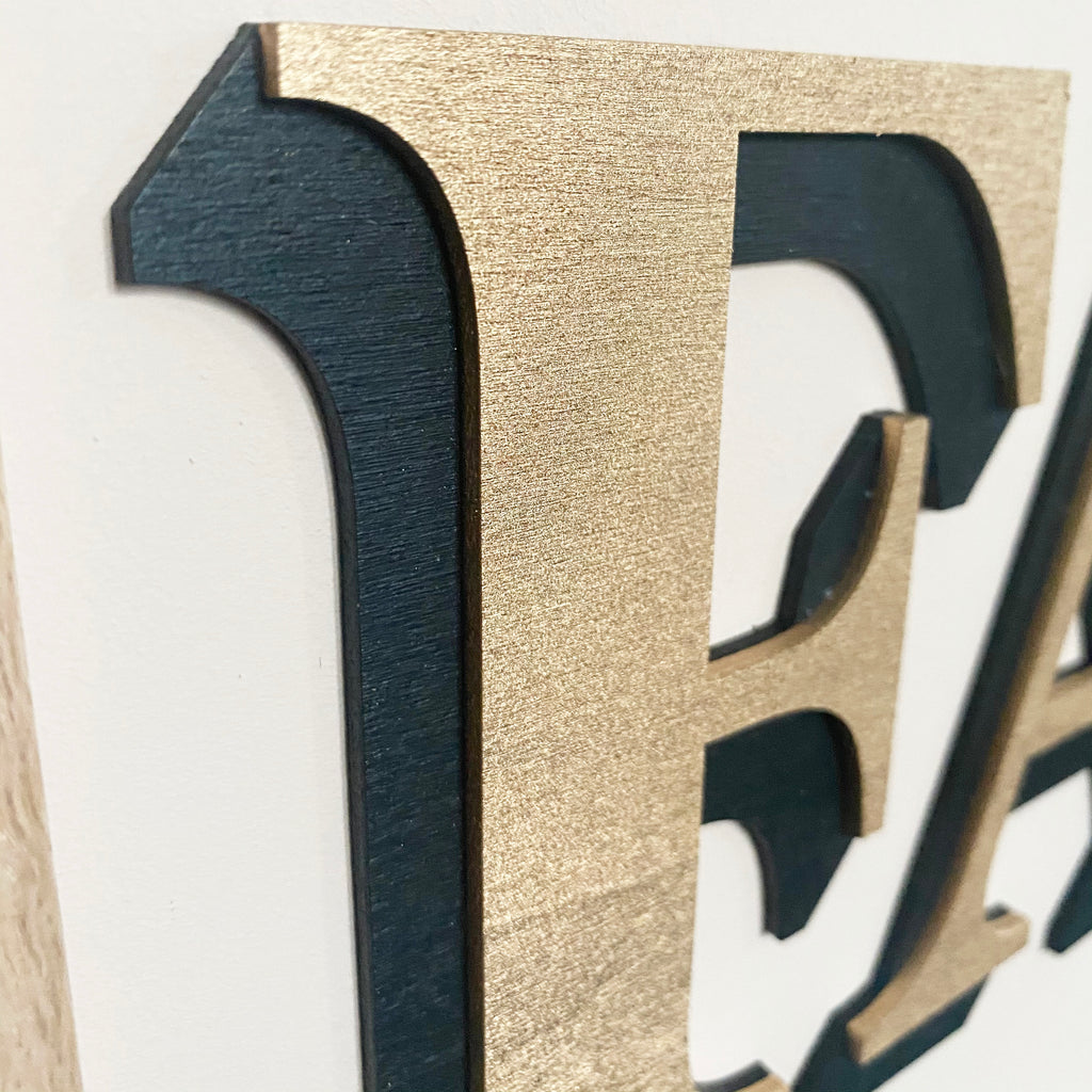 Closeup of quality and gold colour of the one word sign
