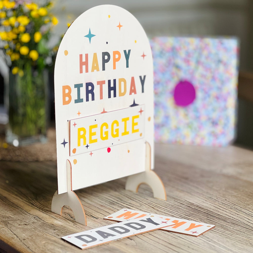 family birthday sign with interchangeable names made by Modo. wooden bright colours and freestanding