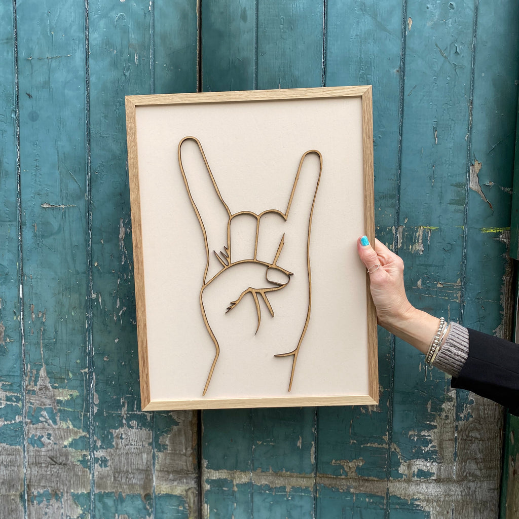 cream hand painted wooden gesture sign with Sign of the horns gesture in wood over the top