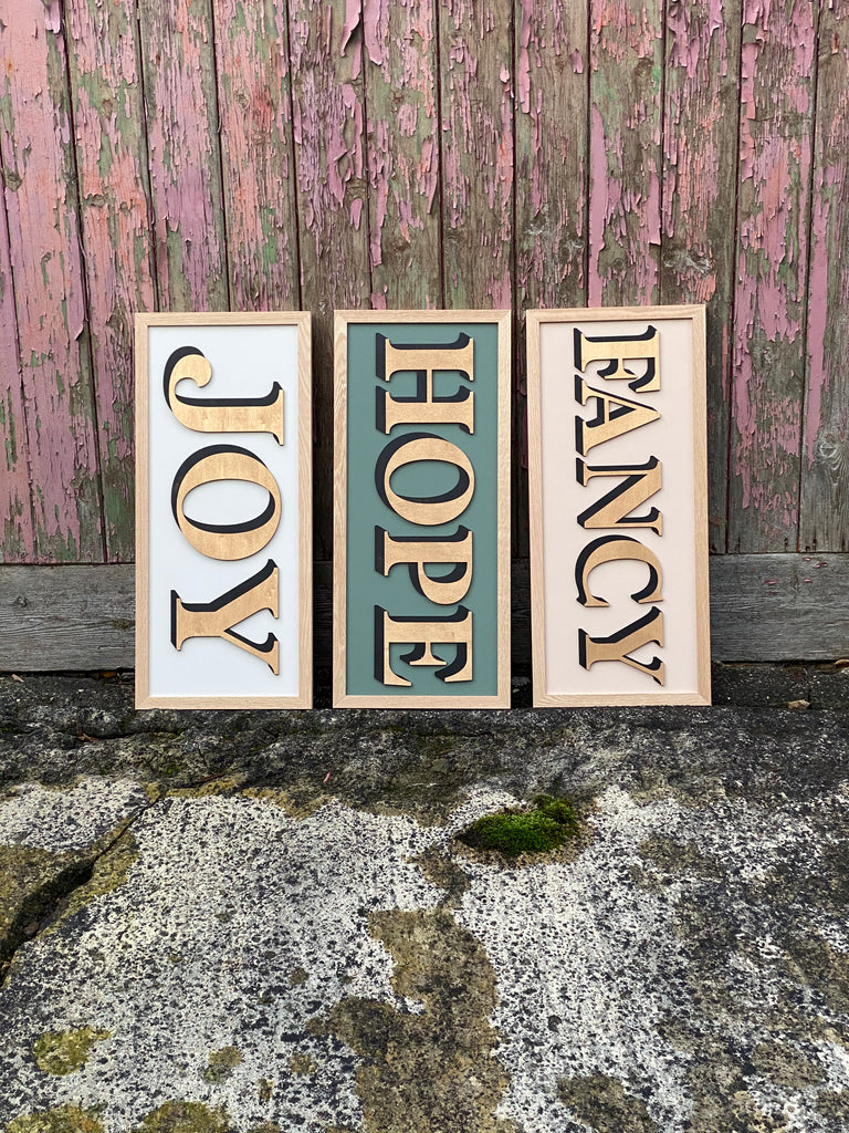 Selection of 3 one word signs displaying the words 'Joy' 'Hope' and 'Fancy' in gold, on textured backdrop