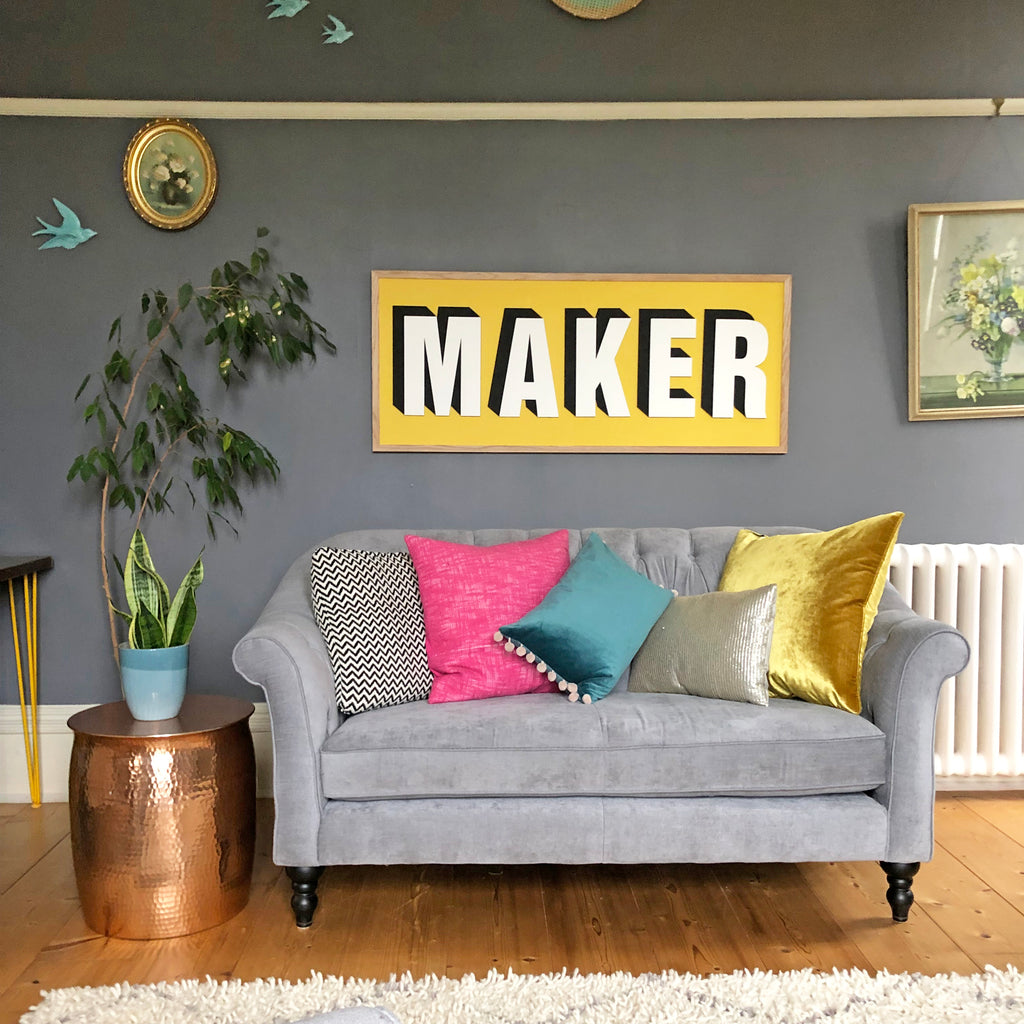 Bold bright front room. Bright wooden sign, wall art. Oak frame, drop shadow. Maker, Lamp lighter Craig and Rose