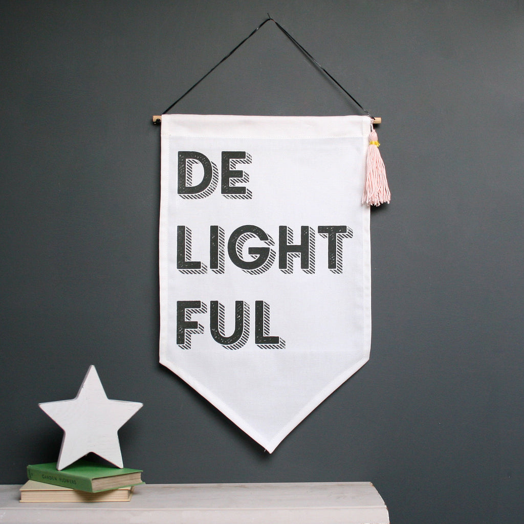 Black and white fabric hanging displaying the word 'Delightful'