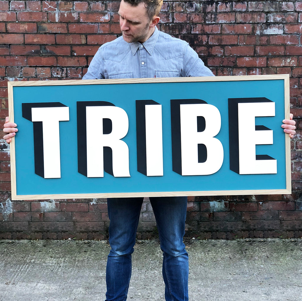 Tribe drop shadow painted sign on a teal Farrow and Ball background. Framed in oak frame.