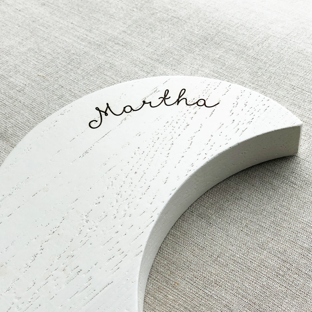 Closeup of word 'Martha' on musical, wooden wall hanging