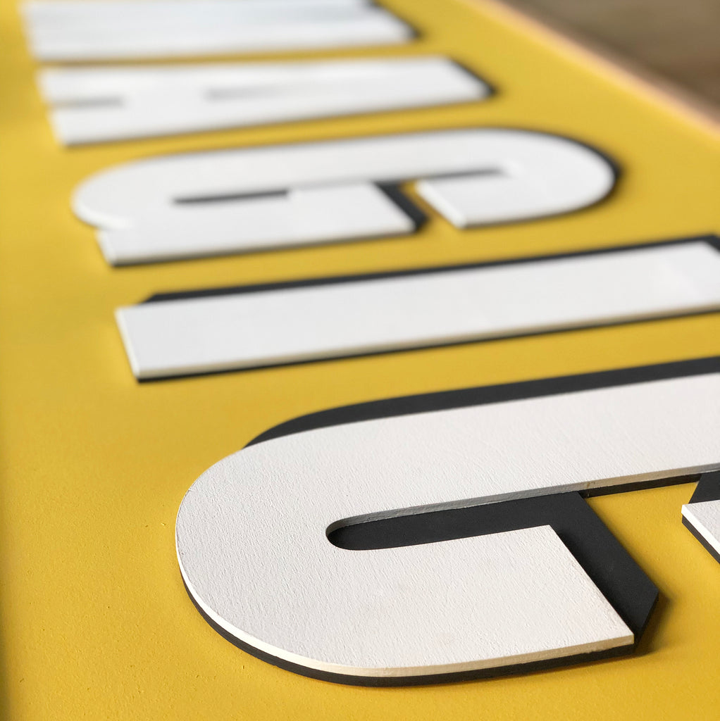 Close up, layered wooden word sign. Farrow and Ball Skimming stone