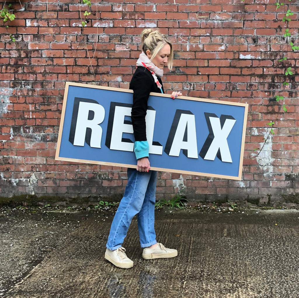 Relax, wooden word sign on Stiffkey Blue Farrow and Ball background. Drop shadow, layered wooden sign